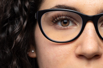 Close up view of young woman face. Caucasian brunette female wearing glasses. Eye and nose detail. Medicine and healthcare concept...