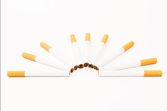 Abanico de cigarrillos rubios con filtro en fondo blanco