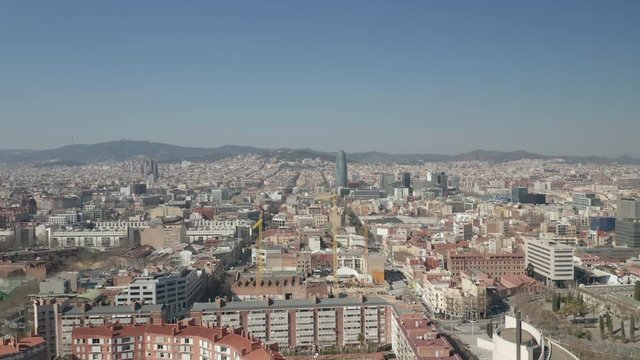 AERIAL: Barcelona Wide Drone Shot of City Towards Center with La Sagrada Familia and Torre Glòries / Torre Agbar [4K]