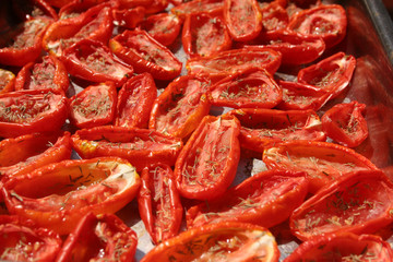 Sun dried tomatoes drying in the sun covered in rock salt and thyme