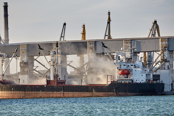 Port grain elevator. Industrial sea trading port bulk cargo zone Railway wagon in grain terminal