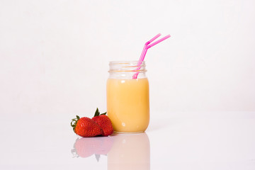 Vaso de Zumo de naranja con fresas y pajitas rosas