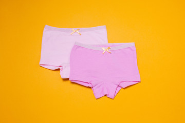 Fototapeta na wymiar Underwear clothes for baby girl on yellow background.