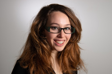 Portrait of gorgeous smiling brunette girl wearing glasses. Young girl with nice brown loose hair....