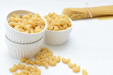 Italian long and short pasta, on white wooden background