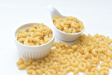Italian short pasta, on white wooden background
