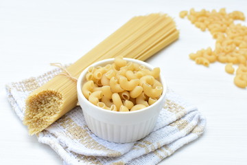 Italian long and short pasta, on white wooden background