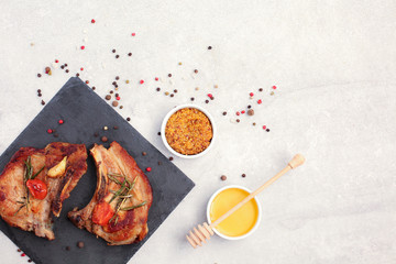 Roasted pork loin steaks with spices on black stone.