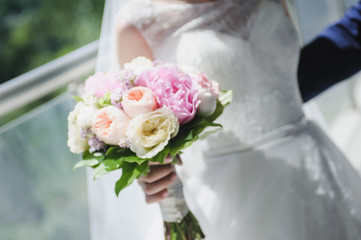 beautiful modern wedding bouquet in bride's hand. Girl in a white wedding dress. Love and tenderness.