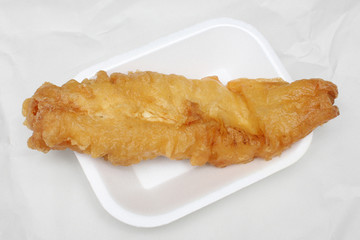 Deep fried cod in batter from a British Fish and Chips takeaway