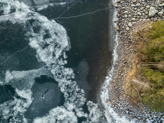 Icy patterns on ice cover of a frozen lake at shore