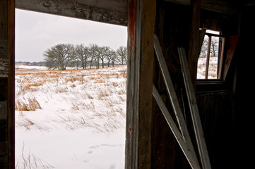 Looking out at the winter prairie from inside a Midwest barn.