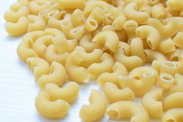 Italian short pasta, on white wooden background