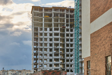 Fototapeta premium Construction site. High rise Building under construction. Construction of high-rise residential building