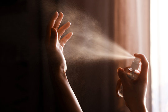 Close up of man's hands using antiseptic spray
