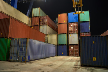 operation of container terminal at night. Unloading container ship at night. Mooring cranes unload container ship at night
