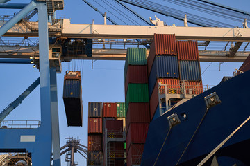 Container ship in port at container terminal. Ships of container ships stand in terminal of port on loading, unloading container at day time.