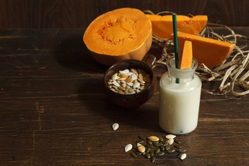 serving vegetable milk without animal fats from pumpkin on a dark wooden table,view from above