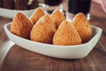 Brazilian appetiser coxinha de frango, kibbe and two glass of soft drink