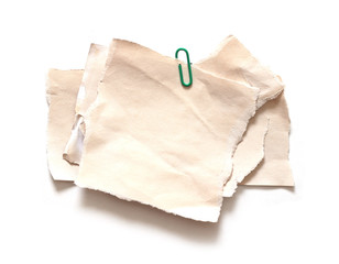 Pieces of old torn paper with paperclip on white background, Copy space.