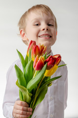 Cute little boy holding a bouquet of flowers. Tulips. Mothers Day. International Women's Day.