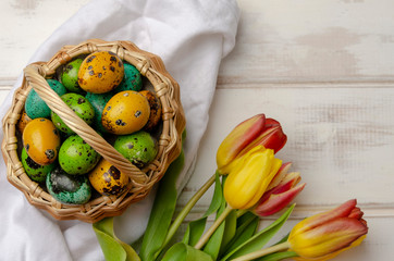 Easter eggs in basket on color wooden background.Top view with copy