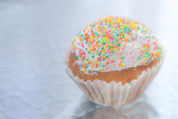 Easter cupcake wrapped in white paper on te table.