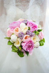 beautiful modern wedding bouquet in bride's hand. Girl in a white wedding dress. Love and tenderness.