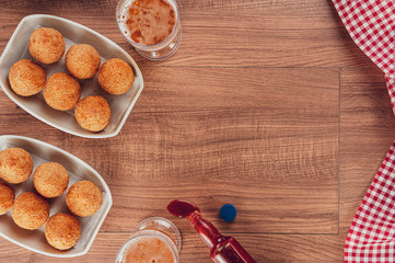 Top view of table with beer, brazilian appetiser coxinha de frango and pepper sauc