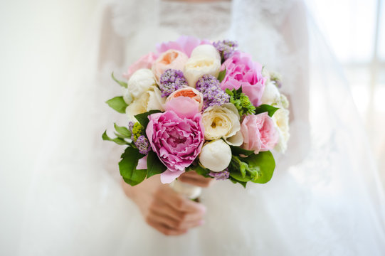 beautiful modern wedding bouquet in bride's hand. Girl in a white wedding dress. Love and tenderness.