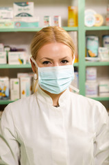 Closeup shot of female pharmacist  with face mask smiling 