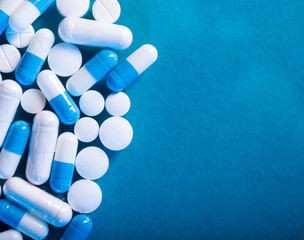 Antibiotic and probiotics pills on a blue background. Pharmaceutical concept with empty space for text.