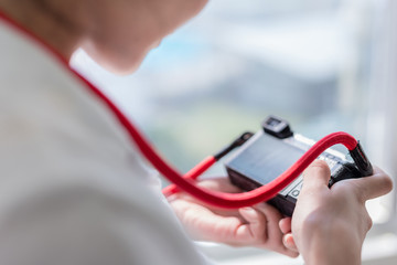Woman is professional photographer holding a mirrorless camera