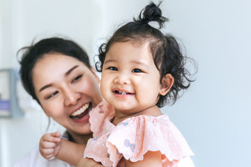 Asian mother and daughter smile happy in house on the white