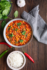 Indian meal, spicy chickpea curry with spinach in a bowl served with rice