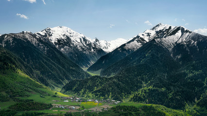 Fototapeta na wymiar Village among the mountains, green meadows and snow Svaneti
