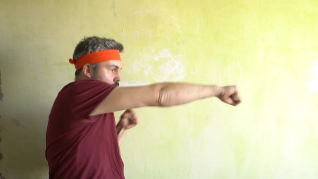 Bearded man against the wall. Good mood. Engaged in martial arts. Repair work in the room. Frick.