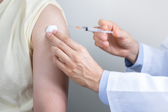 Asian man get coronavirus, flu and measles vaccine shot, vaccination in hospital for good heath, medicine injection vial dose for treatment patient. (select focus)