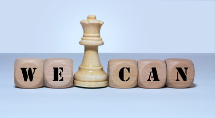 We Can on wood cubes and King chess piece.