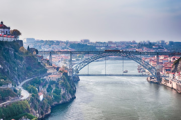 Fototapeta na wymiar Travel Ideas. Cityscape of Porto Across The Douro River in Portugal with Red Rooftops in Background