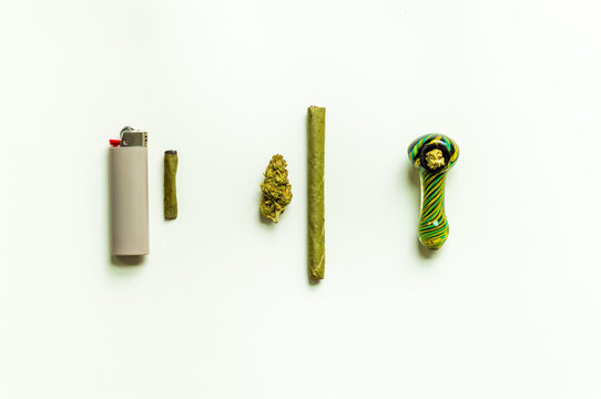 Simple marijuana flat lay. Marijuana flower, blunt, packed smoking bowl, weed roach and a lighter.