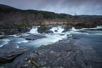 the waterfalls in Glen Orchy near Bridge of Orchy in the Argyll region of the highlands of Scotland during winter whilst the river is flowing fast from rainfall