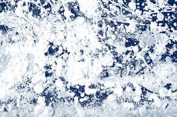 spots and splashes of white paint on a dark blue background. abstract pattern for decoration