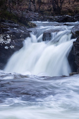 Fototapeta premium the waterfalls in Glen Orchy near Bridge of Orchy in the Argyll region of the highlands of Scotland during winter whilst the river is flowing fast from rainfall