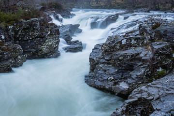 the waterfalls in Glen Orchy near Bridge of Orchy in the Argyll region of the highlands of Scotland during winter whilst the river is flowing fast from rainfall