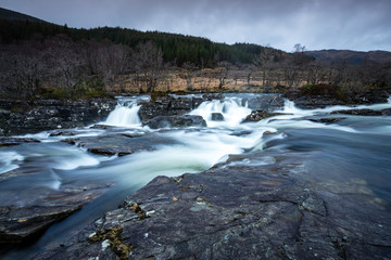 Fototapeta na wymiar the waterfalls in Glen Orchy near Bridge of Orchy in the Argyll region of the highlands of Scotland during winter whilst the river is flowing fast from rainfall