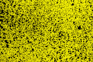 Distressed splatter texture. Ink blots background. Grunge black spray spots on yellow surface.