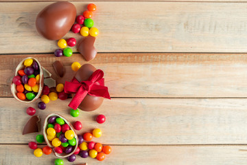 Easter sweets - chocolate eggs and sweets on a brown background.
