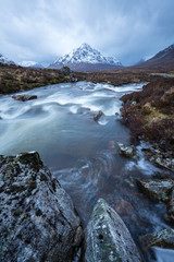 the river coupall waterfalls on rannoch moor showing buachaille etive mor in the background as the entrance to glencoe valley in winter