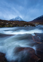 the river coupall waterfalls on rannoch moor showing buachaille etive mor in the background as the entrance to glencoe valley in winter